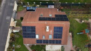 Pohled z dronu na střechu domu pokrytou fotovoltaikou